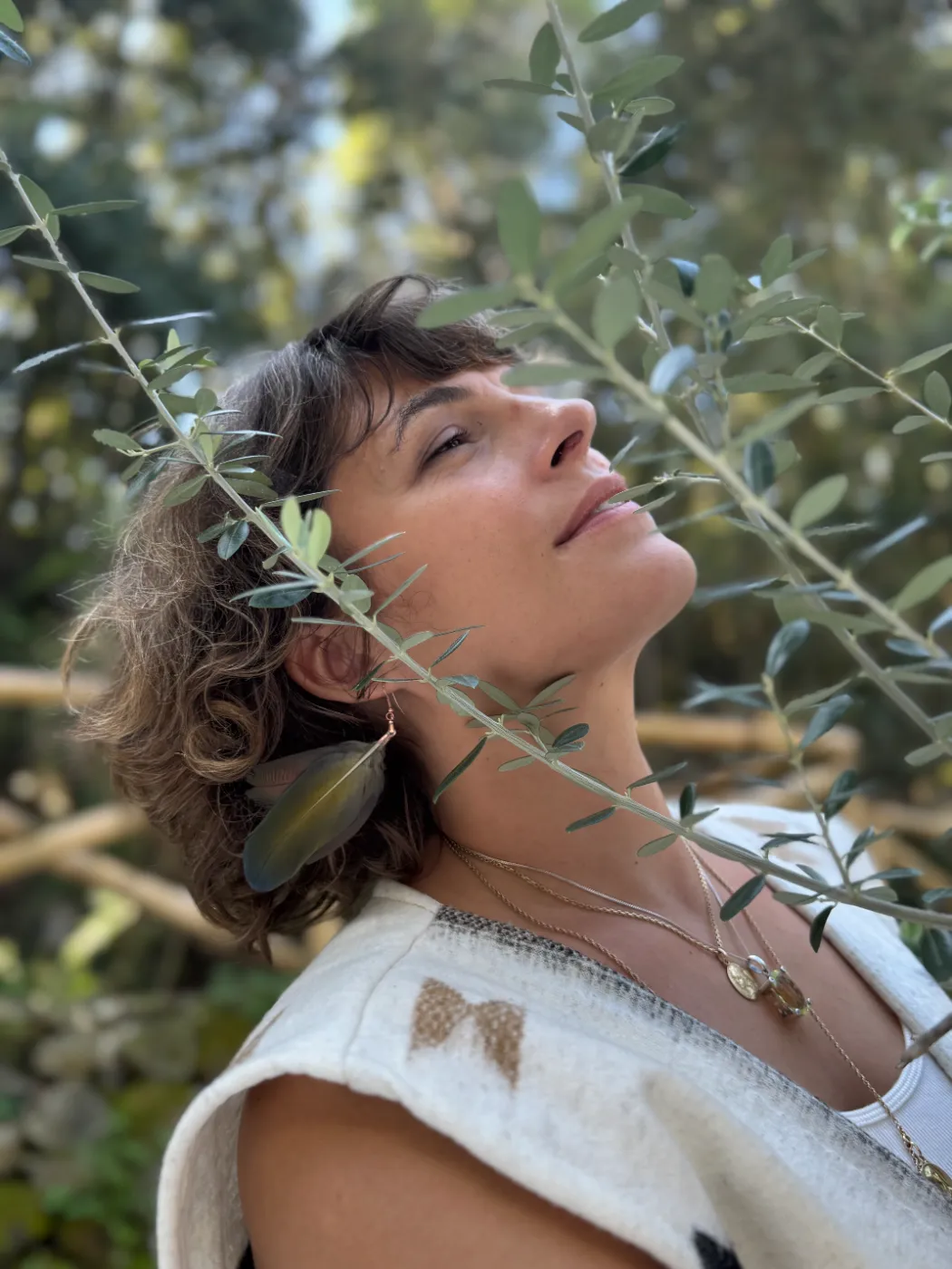 Visage tourné vers la lumière, entre les oliviers